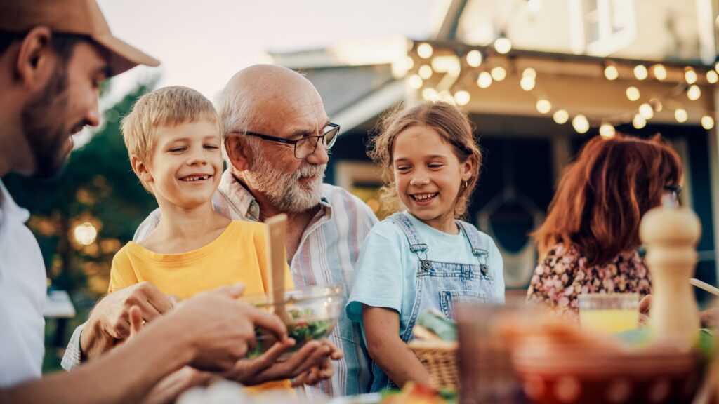 Eine Familie sitzt draußen und lacht