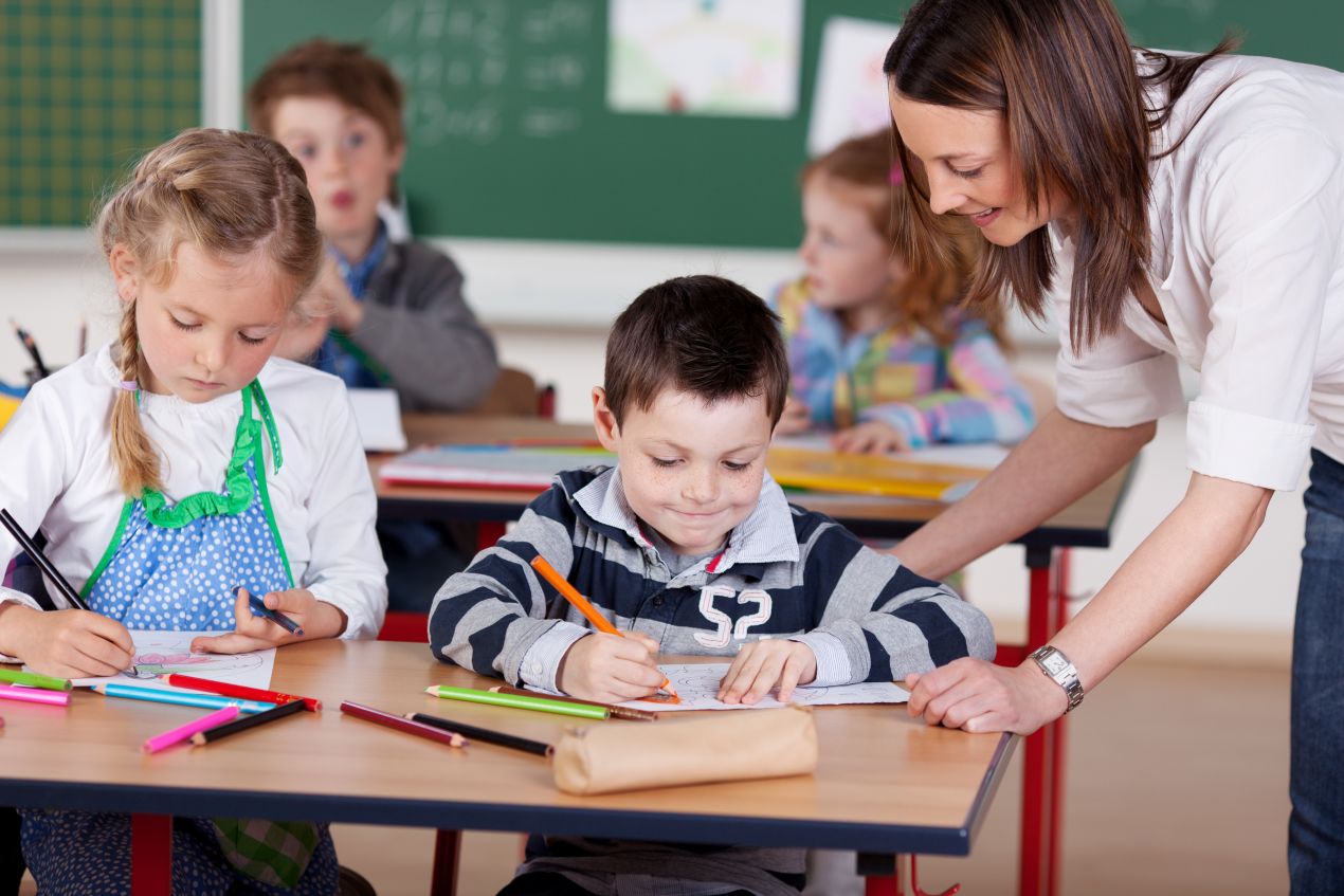 Lehrerin unterstützt Schüler im Unterricht – individuelle Betreuung in einer private grundschule in berlin