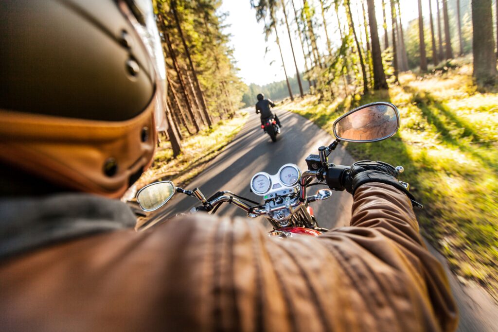Motorradfahrer auf Waldstraße mit Blick aufs Cockpit – Fokus auf Fahrgefühl und Motorrad Schutz