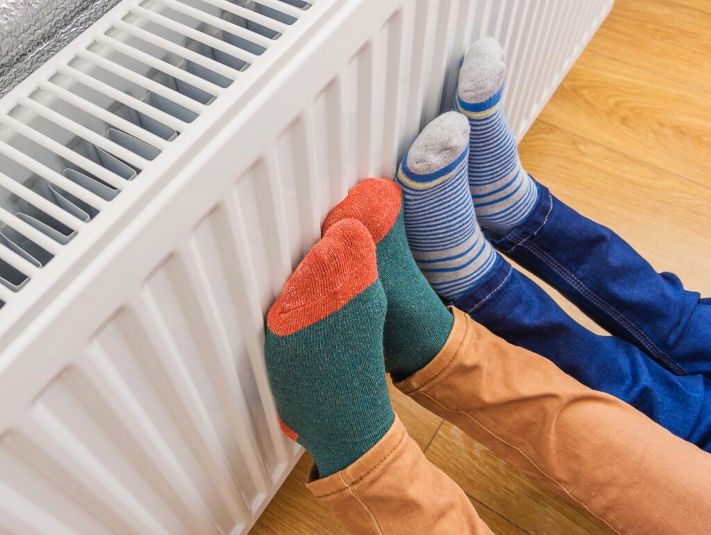 Kinderfüße in Socken vor Heizkörper | Heizölpreise Stuttgart