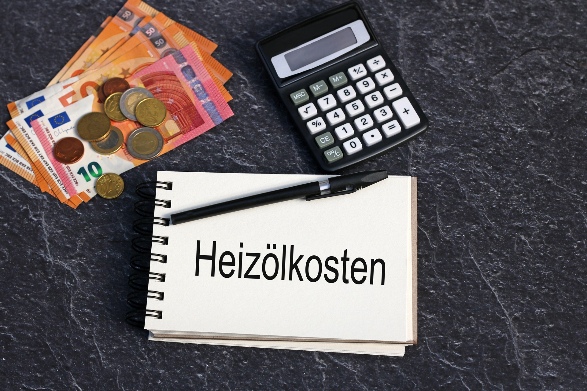 Notiz mit Heizölkosten, Eurogeld und Rechner | Heizölpreise Stuttgart


