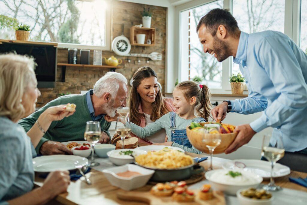 Glückliche erweiterte Familie hat Spaß beim Mittagessen im Esszimmer.